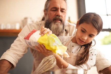 Photo for Girl, child and grandfather with flour in kitchen for cooking, baking and teaching with support or helping. Family, senior man and grandchild with dough preparation in home for bonding and learning. - Royalty Free Image