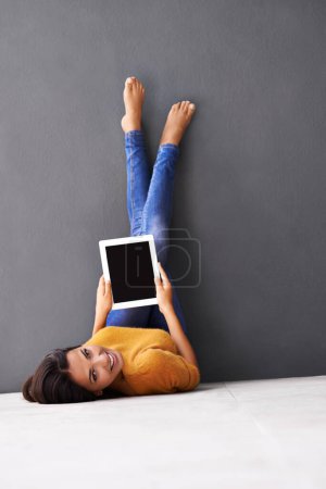 Photo for Portrait, feet up or woman with tablet screen on floor for social media, scroll or search on wall background. Digital, space or person face on ground with google it, sign up or Netflix and chill app. - Royalty Free Image