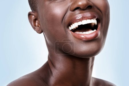 Photo for Mouth of woman, happy or laughing with beauty, cosmetics or healthy skin for shine isolated in studio. Face, closeup or funny girl model with lip gloss, smile or skincare results on blue background. - Royalty Free Image