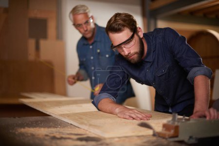 Photo for Wood, father and son in a workshop, architect and carpenter with renovation or safety glasses with protection. Parent, men or teamwork with construction or building with planning for project or gear. - Royalty Free Image