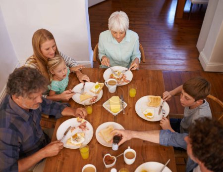 Photo for Family, children and eating food from above for healthy nutrition meal, wellness or bonding. Women, grandmother and breakfast with daughter at lunch table in apartment for morning, brunch or hungry. - Royalty Free Image