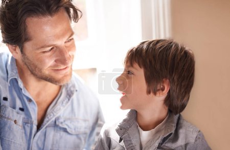 Photo for Dad, boy and smile conversation in home, happy son and man bonding for child development and paternal relationship. Kid, family vacation house and male person listening or discussion on Fathers day. - Royalty Free Image
