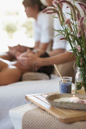 Salt, flowers or couple in spa to relax on bed or break with luxury pamper treatment tools or candles. Flamingo feather celosia, facial or people at resort for natural healing benefits or massage.