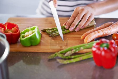 Photo for Chopping, healthy and cooking in home kitchen, organic food or meal prep with fresh produce. Diet, nutrition and cutting board for wellness ingredient, pepper asparagus or carrot in vegan lunch snack. - Royalty Free Image
