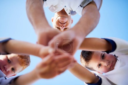 Photo for Children, coach and hands together for soccer or bonding for motivation for game, teamwork and tradition. Portrait, low angle and huddle for support or unity for football sports, victory and outdoor - Royalty Free Image
