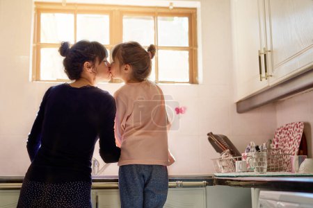 Photo for Family, mom and girl kiss in kitchen washing dishes for help, learning and development of house skills . Cleaning, mother and daughter by sink together for hygiene, teaching and support in home. - Royalty Free Image