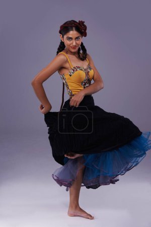 Foto de Bailarina, estudio o mujer en vestido bailando con energía, libertad o moda en retrato para estilo. Espanol, fondo morado o artista en flamenco, tango o performance en cultura o tradición musical. - Imagen libre de derechos