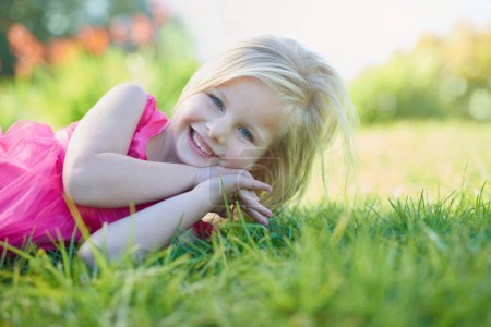 Téléchargez les photos : Portrait, sourire et fille enfant sur l'herbe dans le champ ou la nature pour les vacances d'été ou de vacances. Jardin, parc et sourire avec un jeune enfant heureux en plein air pour le développement, la croissance ou la paix sur la pelouse verte. - en image libre de droit