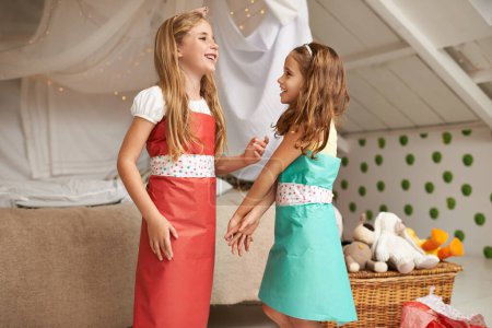 Photo for Fashion, paper and children friends with dress for fun, show or playing together at home. Happy, smile and young girl kids in gift wrap outfit for style with bonding in bedroom at modern house - Royalty Free Image