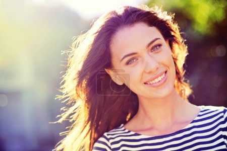 Photo for Woman, portrait and smile with nature, sunrise and park for happiness and wellness. Person, joy and bokeh with closeup, glow and sunshine for summer relax and adventure outside in garden with trees. - Royalty Free Image
