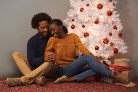 Photo for Christmas, tree and black couple in home with love on holiday or hug on vacation with happiness. Festive, house and people embrace with care and support or excited to celebrate at event together. - Royalty Free Image