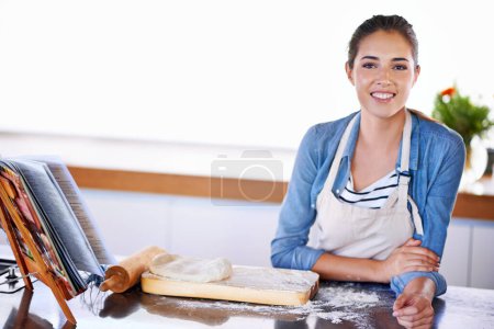 Téléchargez les photos : Portrait, sourire pour la cuisson et femme dans la cuisine de la maison avec de la pâte, de la farine ou des ingrédients de pâtisserie pour le pain ou le gâteau. Nourriture, recette et poêle avec jeune boulanger heureux préparant le dessert dans l'appartement. - en image libre de droit