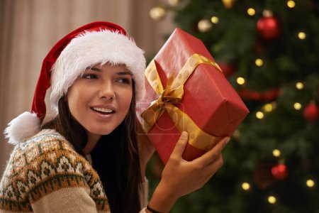Photo for Christmas, happy and woman with present at her home for festive celebration, event or party. Smile, guess and young female person with gift box for xmas surprise in living room at modern apartment - Royalty Free Image