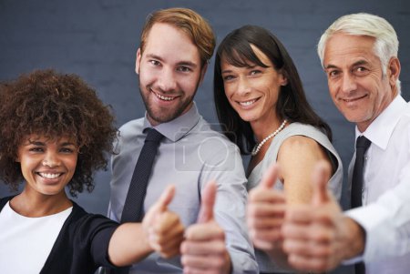 Photo for Business people, teamwork and thumbs up in studio portrait for success, winning and achievement or thank you emoji. Professional group with mature boss for like, yes and feedback on a wall background. - Royalty Free Image