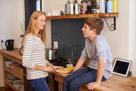 Photo for Mother, child and food preparation in kitchen for morning breakfast on counter for toast meal, brunch or snack. Woman, son and conversation in home for healthy nutrition or hungry, wellness or diet. - Royalty Free Image