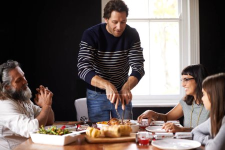 Photo for Family, Christmas and dad carving turkey for festive lunch, bonding and eating together in home. Holiday, celebration and happy people at table with food, drinks and xmas dinner tradition with smile. - Royalty Free Image