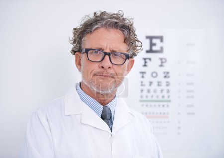 Photo for Test, eye and portrait of optometrist in clinic with glasses to check vision and exam in healthcare. Mature, doctor and reading letters on wall in medical assessment for contact lenses or eyesight. - Royalty Free Image