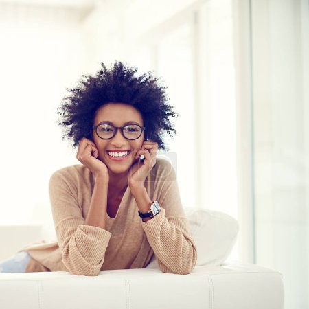 Photo for Happy, home and portrait of black woman, relax on sofa and cheerful with weekend break, afro and chilling. African person, apartment and girl with glasses, clear vision and carefree with sunshine. - Royalty Free Image