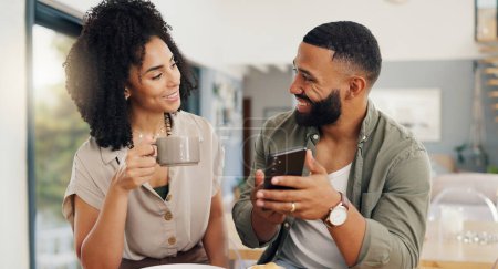 Photo for Couple, happy and coffee with smartphone for social media, sharing music or app explanation. Man, woman and technology in kitchen with breakfast for morning, relaxing and scrolling on online website. - Royalty Free Image