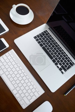 Photo for Laptop, mobile and tablet in office with digital devices for business research, communication or collaboration. Smartphone, mouse and coffee in workspace with tech for online company or connection. - Royalty Free Image