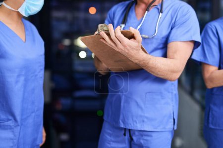 Photo for Hospital, clipboard and hands of nurse team for medical service, writing notes and diagnosis results. Healthcare, clinic and men and women with checklist for research, planning and surgery schedule. - Royalty Free Image