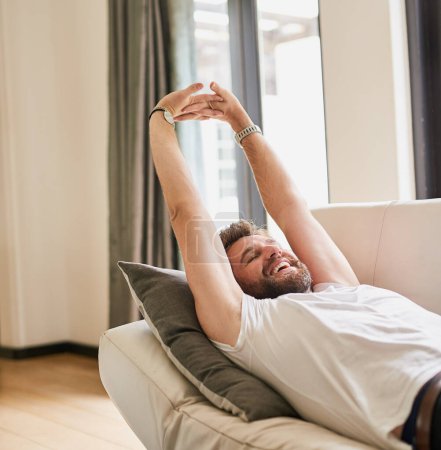 Photo for Relax, stretching and man in home, couch and chill on break, weekend and time for holiday with peace. Apartment, rest and sleeping of person in house, smile and happiness in morning, lounge and lazy. - Royalty Free Image