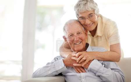Photo for Couple, senior and hug or sofa in portrait, home and relax together for bonding and smile. Elderly people, embrace and care in marriage or relationship in retirement, loyalty and security on couch. - Royalty Free Image
