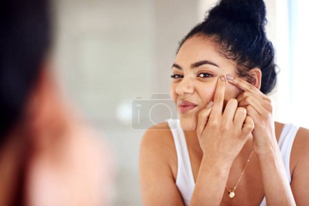 Photo for Skincare, mirror and woman popping acne on face with hands, dirt or scar on skin in home. Dermatology, facial wellness and girl in bathroom to squeeze pimple, checking reflection or morning routine. - Royalty Free Image