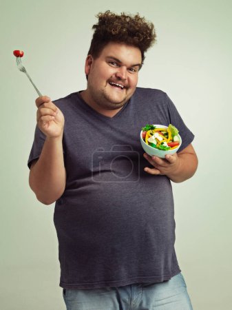 Photo for Studio, portrait and overweight man with salad for weight loss, diet and healthy meal with nutrition. Obese, male person and smile with organic food for detox, lifestyle change and vitamin c benefits. - Royalty Free Image