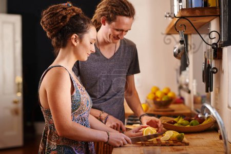 Photo for Home, happy couple and cutting orange in kitchen for healthy diet, nutrition or wellness. Man, woman and chopping board with fruit at table for meal prep or food for organic breakfast in rasta house. - Royalty Free Image