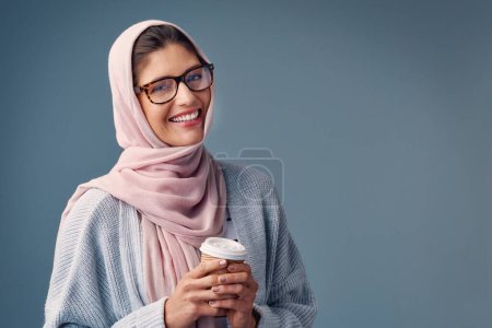 Porträt, Lächeln und islamische Frau mit Kaffee auf Studiohintergrund und selbstbewusstes Mädchen. Gesicht, muslimische Person und glückliches Model mit Morgentee und Espresso mit Cappuccino und Hijab mit Kultur.