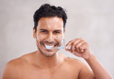 Foto de Higiene oral, retrato y hombre en el baño para cepillarse los dientes, el autocuidado y la rutina matutina. Dental, sonrisa y cara de hombre mexicano en casa para el bienestar, cepillo de dientes y boca sana - Imagen libre de derechos