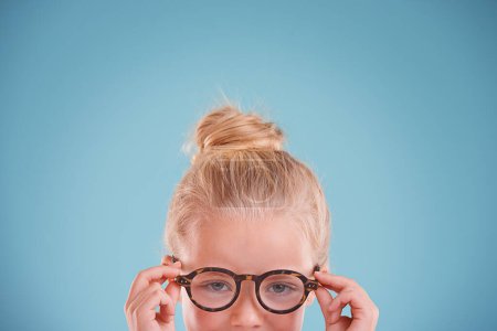 Photo for Child, portrait and glasses in studio for vision optometry on blue background for frames, wellness or mockup space. Girl, kid and face with eyewear healthcare for sight spectacles, lens or optical. - Royalty Free Image