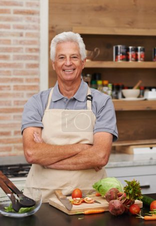 Älterer Mann, Porträt und Arme gekreuzt beim Kochen, Essen und Gemüse mit Schürze und Lächeln in der Küche. Reifer Mensch, glücklich und Zubereitung von Mahlzeiten zu Hause für Ernährung, gesund und Ernährung im Ruhestand.