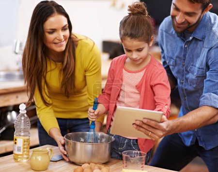 Photo for Family, kitchen and baking with tablet for recipe online with ingredients for cake or dessert with support and handmade. Mom, dad and girl child cooking together with love for bonding or teaching - Royalty Free Image
