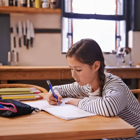 Photo for Girl, child and homework with studying in kitchen with writing, development or notes for education in house. Kid, notebook and thinking with learning, language and ideas for assessment in family home. - Royalty Free Image