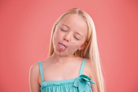 Photo for Silly, funny and girl with expression for prank, mischief and fun in childhood isolated in studio background. Female child, gen z kid and tongue out for joke, cheerful and goofy or playful face. - Royalty Free Image