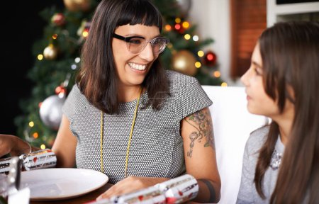 Téléchargez les photos : Table, Noël et maman avec leur fille au déjeuner pour les liens festifs et manger ensemble à la maison. Vacances, célébration et personnes heureuses au dîner de Noël avec plaisir, rire et fille enfant avec sourire. - en image libre de droit