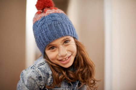 Photo for Girl, portrait and child with fashion in winter at home with pride and confidence in clothes with beanie. Kid, smile or relax in house with hat, jacket or casual style on holiday or vacation. - Royalty Free Image