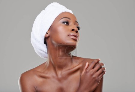 Photo for Black woman, glow and cosmetics with dermatology, shine and healthy skin on white studio background. Glow, African person and model with wellness and towel with makeup, spa treatment and aesthetic. - Royalty Free Image
