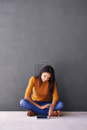 Photo for Tablet, search and woman on a floor with social media, scroll or elearning research on wall background space. Digital, mockup or lady student in a house with app for ebook, course or online education. - Royalty Free Image