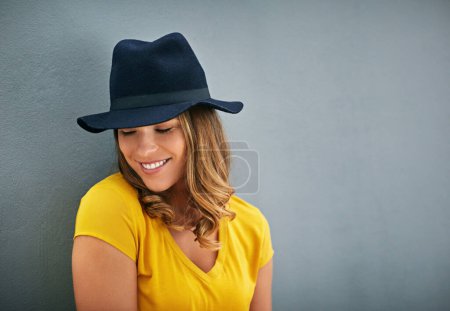 Photo for Woman, smile and hat by gray background with fashion inspiration, clothes and mockup for marketing. Happy, confidence and face of gen z person by dark wall with advertising space, fedora and style. - Royalty Free Image