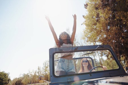 Foto de Mujeres felices, emocionadas y viajando en viaje por carretera en la naturaleza y uniéndose para la aventura en vacaciones. Amigos, conducción y viaje en furgoneta convertible de vacaciones, campo y diversión al aire libre en Texas. - Imagen libre de derechos