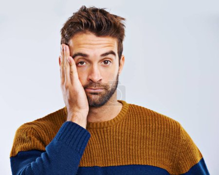 Photo for Bored man, portrait and headache with stress, depression or anxiety on a white studio background. Young guy, tired model or upset male person in mistake, disappointed or mental health on mockup space. - Royalty Free Image