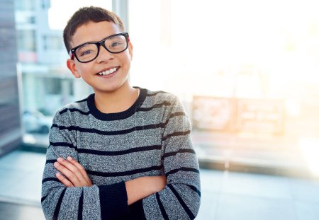Photo for Happy, boy kid and arms crossed with glasses for eye care and optometry at home with lens flare. Smile, young male child and prescription spectacles or frame in portrait for sight and development. - Royalty Free Image
