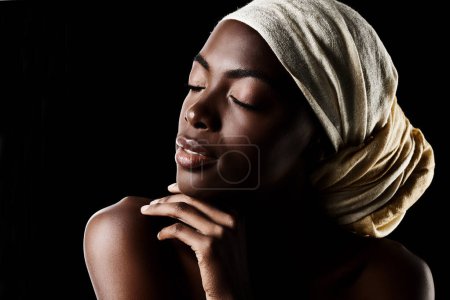Téléchargez les photos : Beauté, profil et femme noire avec tête enveloppée, maquillage naturel ou esthétique créative en maquette studio. Art, soins de la peau et fille africaine sur fond sombre avec écharpe, cosmétiques du visage et confiance - en image libre de droit