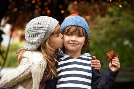 Photo for Children, love and siblings kiss in a park for travel, adventure or bonding on autumn journey in nature. Family, support and kids hug in a forest for explore, playing or fun games in Canada outdoor. - Royalty Free Image