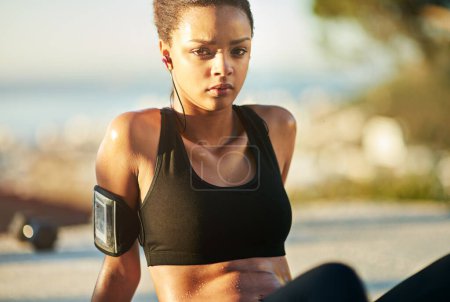 Photo for Tired woman, portrait and workout at sunset with music or podcast for fitness, health and relax outdoors. Earphones, sports and female athlete for training, sweating and exercise in summertime. - Royalty Free Image