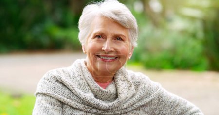 Téléchargez les photos : Parc, heureux et portrait de femme âgée dans la nature pour le soleil, l'environnement et la retraite. Personne âgée, détendez-vous et souriez dans le jardin de la maison de soins infirmiers pour le bien-être, la santé mentale et le bien-être. - en image libre de droit