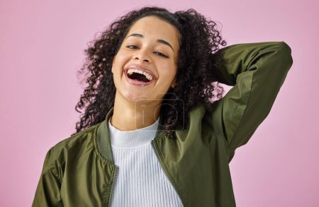 Lustig, Porträt und Lächeln mit Frau auf rosa Hintergrund im Studio für Comedy oder Humor. Comic, Emoji-Gesicht oder lachende und glückliche Person, die Spaß hat oder Witze macht, wenn sie auf verrückte oder dumme Sprüche reagiert.